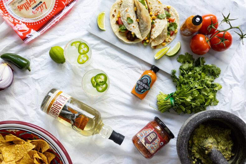 Collection of Cinco de Mayo ingredients, Mexican food, and a Spicy Jalapeño Margarita